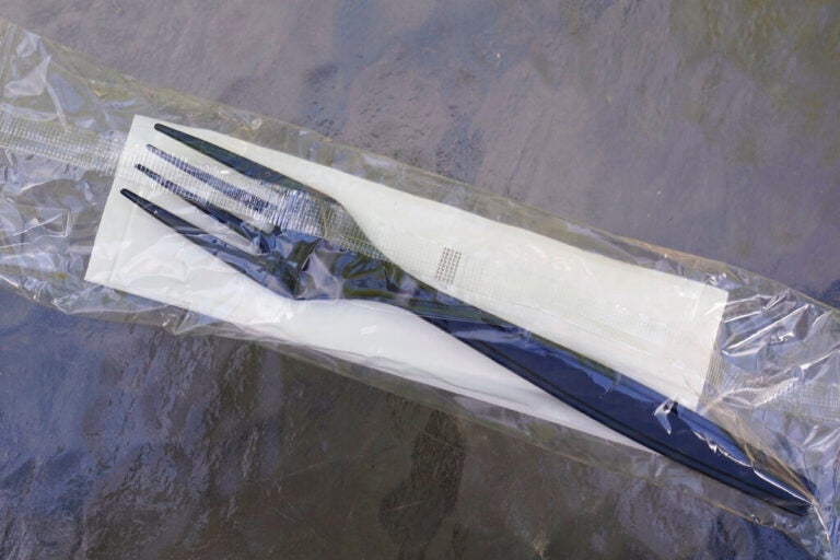 A plastic fork and napkin inside of a plastic wrapper