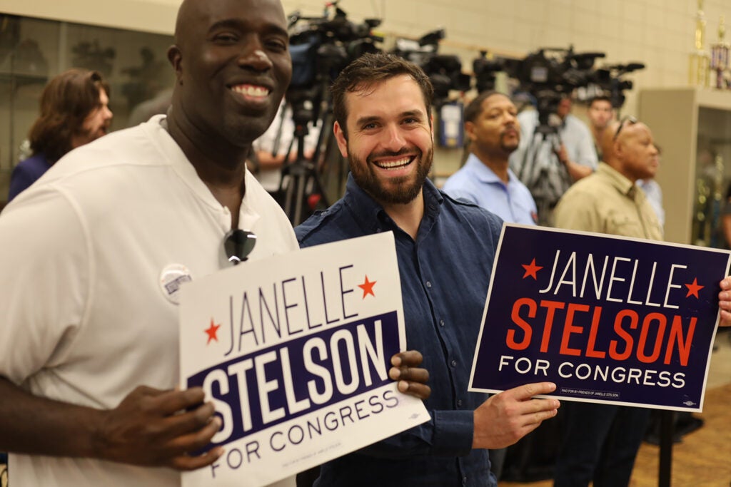 People hold signs supporting Democratic congressional candidate Janelle Stelson