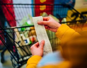 Checking the bill Woman checking the bill when paying at a supermarket