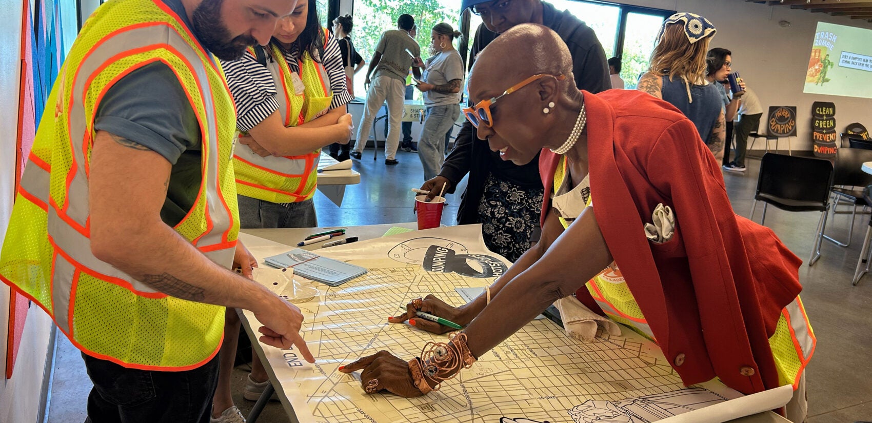 Aminata Sandra Calhoun marking sections on a map laid out on a table.