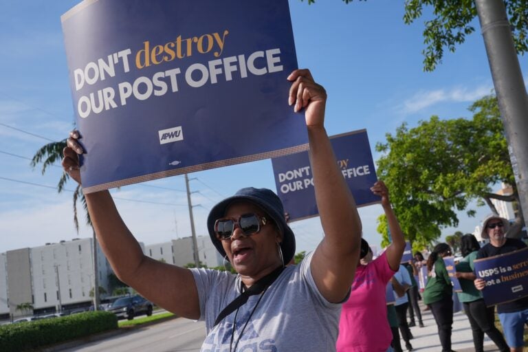 Yvonne Daniels holding up a sign at a pro-USPS protest.