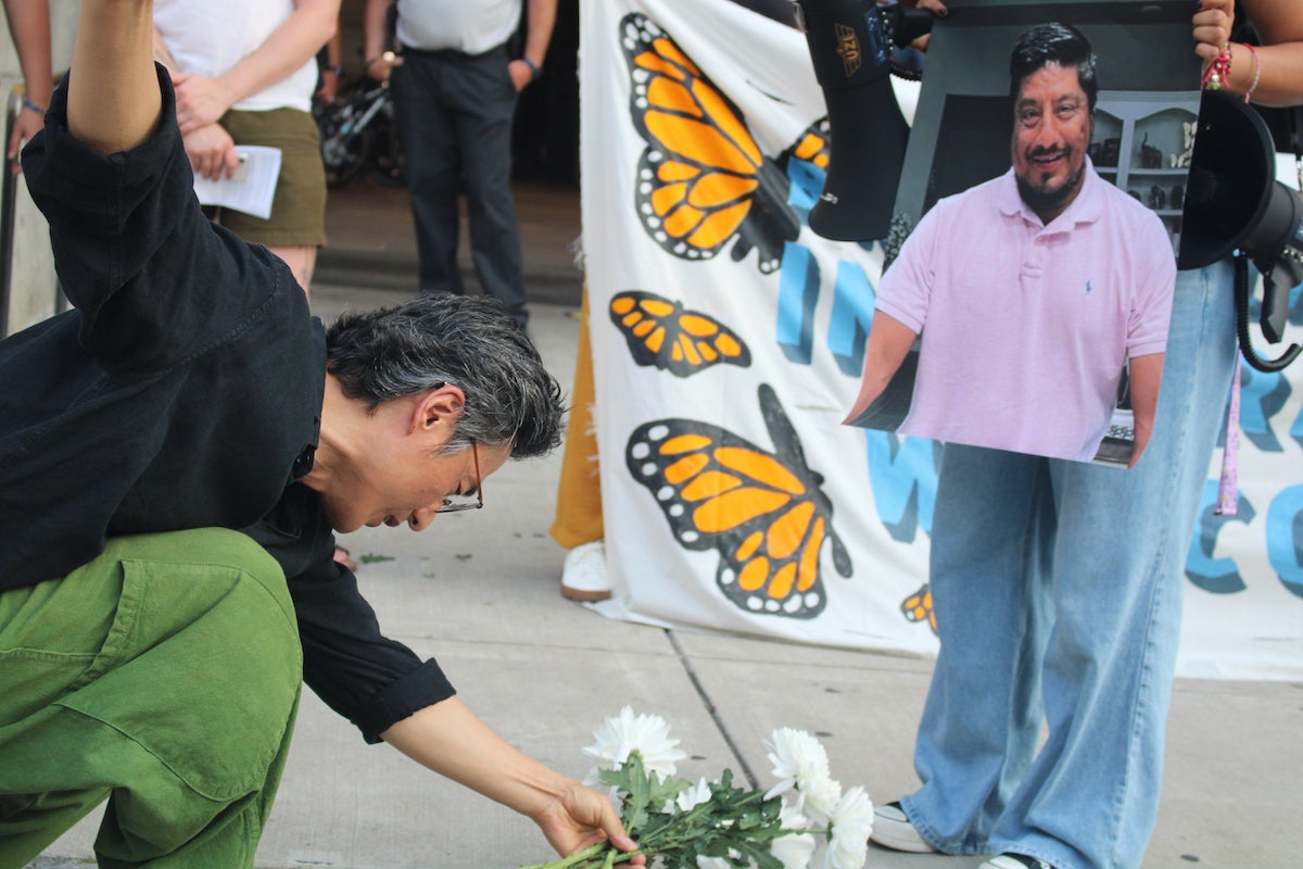 People placing items at the vigil for those killed by ICE officers.