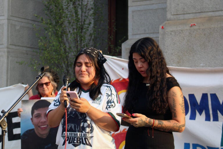 Lenore Ramos Juarez, left, a community defense coordinator at Juntos, and Erika Guadalupe Núñez, executive director of Juntos, speak at a vigil for Joan Sebastian Guerrero and Lorenzo Salgado Araujo outside of of Philadelphia City Hall on Tuesday, July 14, 2026. (Emily Neil/WHYY)