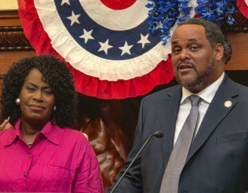 Carlton Williams speaking at a podium in City Hall, with Mayor Cherelle Parker standing beside him.