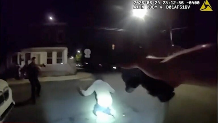 two officers pointing weapons at Kadir Skinner
