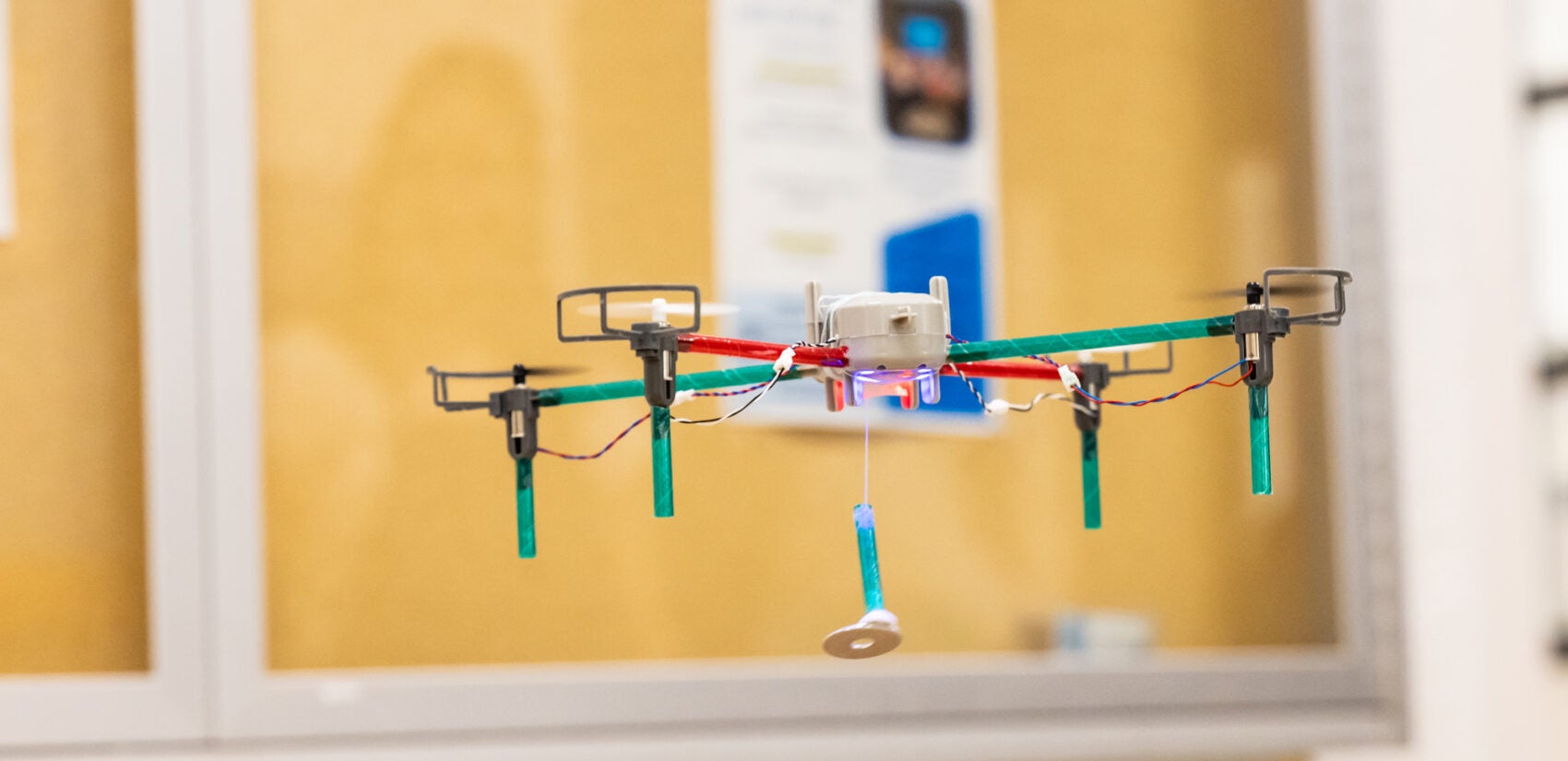 a small drone flying and holding a washer