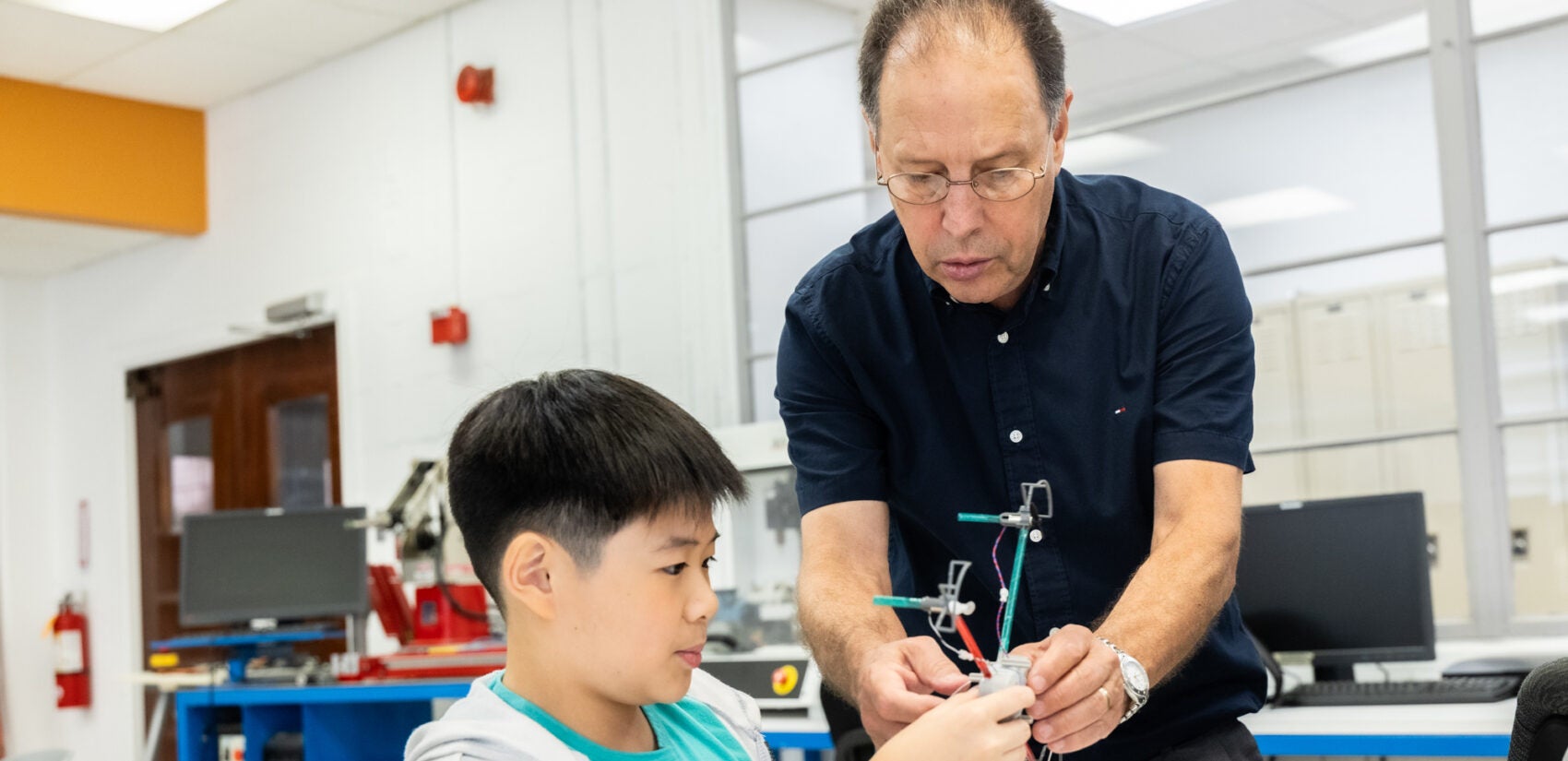 Fernando Tovia helps a child with a drone