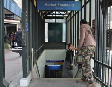 11th-street-station-philadelphia-file a woman gives change to a man