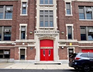 A sign above the bright red door marks the entrance to Kensington High School