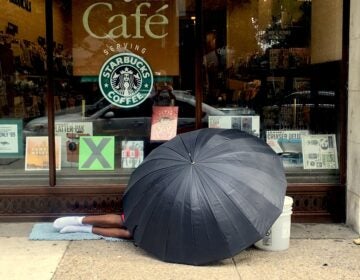 2018 08 21-e lee-rittenhouse square-homeless man under umbrella a person sleeping on the sidewalk, under an umbrella