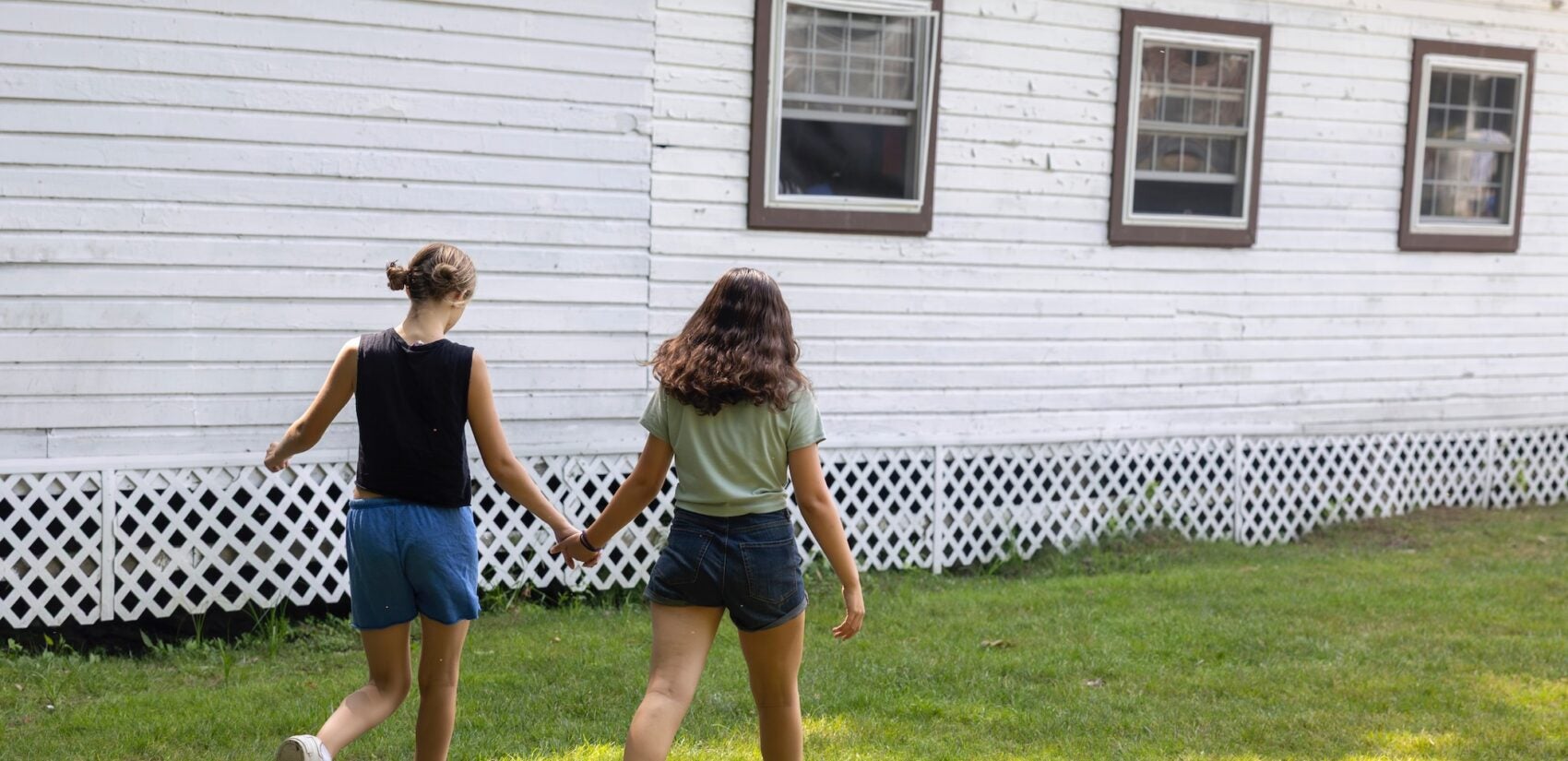 Two campers hold hands while walking