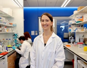 2026 07 30-e lee-brittney allyn-philadelphia university of pennsylvania-mrna research celiac Brittney Allyn is in her busy lab at University of Pennsylvania. Two researchers are working together at at table behind her.