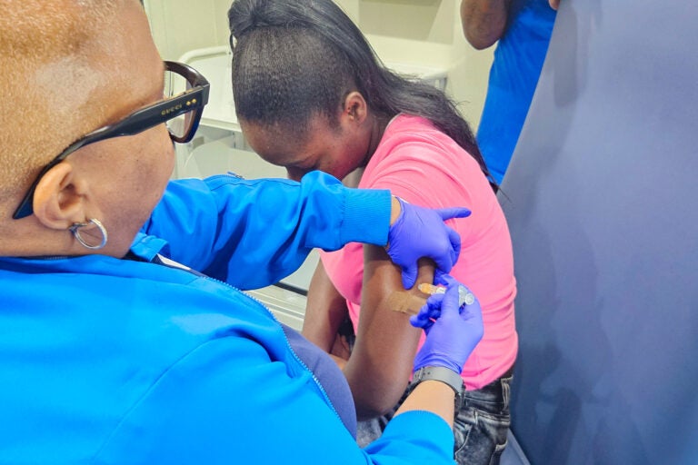 Registered nurse Mia Williams administers a vaccine