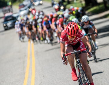 Philly2015DParks Women Kelly Drive-0954 a competitor rides her bicycle in front of other cycling competitors along a road