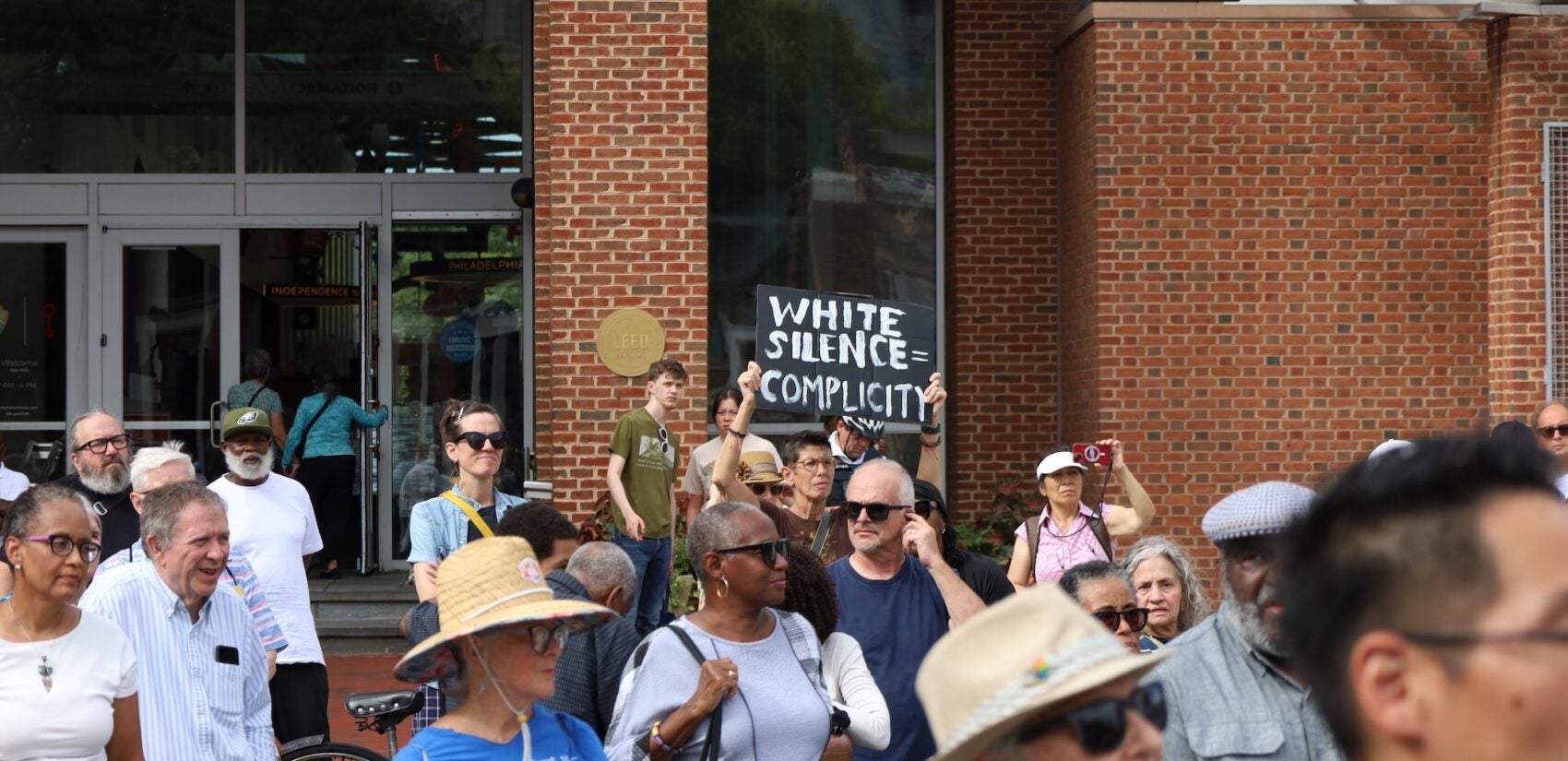 Many people are gathered on Independence Hall at the location of the President's House site.