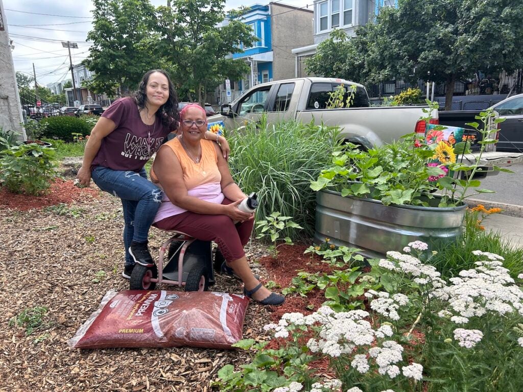 Wanda Lopez (left) and Jacqueline M. Santiago-Vicente standing in the Byron Street community garden