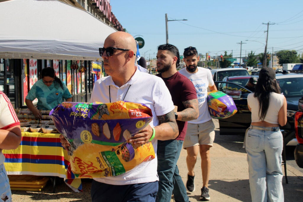 Men carrying packages to go to Colombia walk
