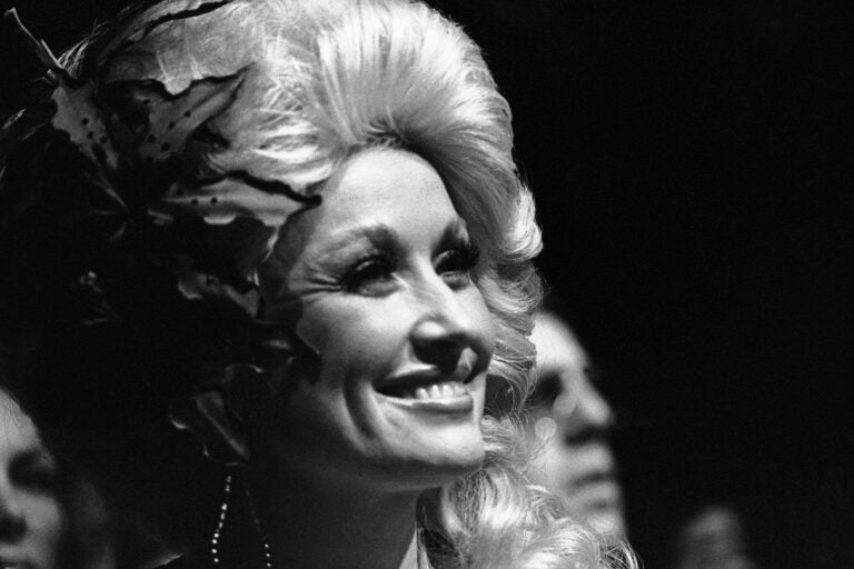 A black-and-white closeup photo of Dolly Parton from 1977.