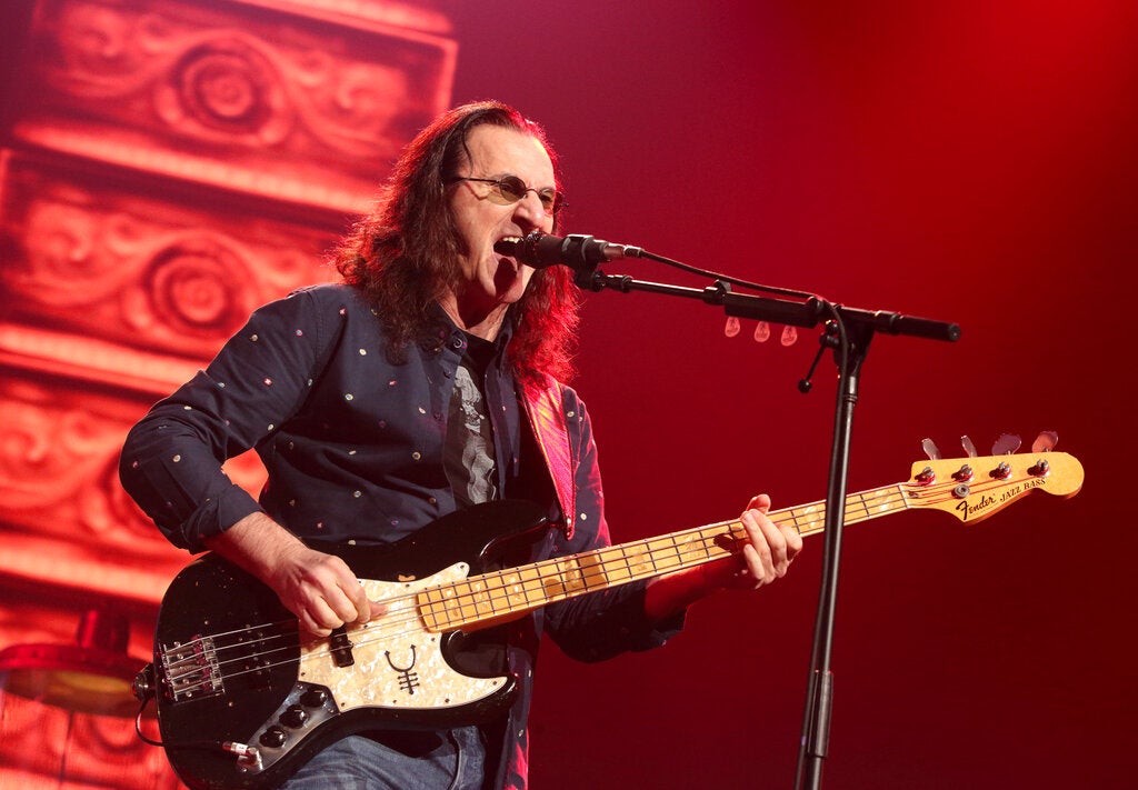 Geddy Lee of the band Rush plays the bass while singing in concert