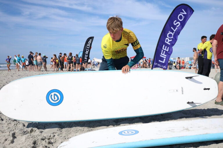 a person holds a surfboard