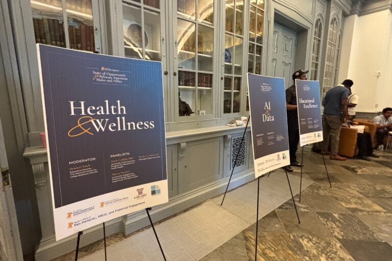 three signs read HEALTH & WELLNESS, AI & DATE AND EDUCATIONAL EXCELLENCE