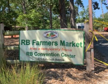 a sign reads Rehoboth Beach Farmers' Market Has a temporary home RB Convention Center 229 Rehoboth Avenue