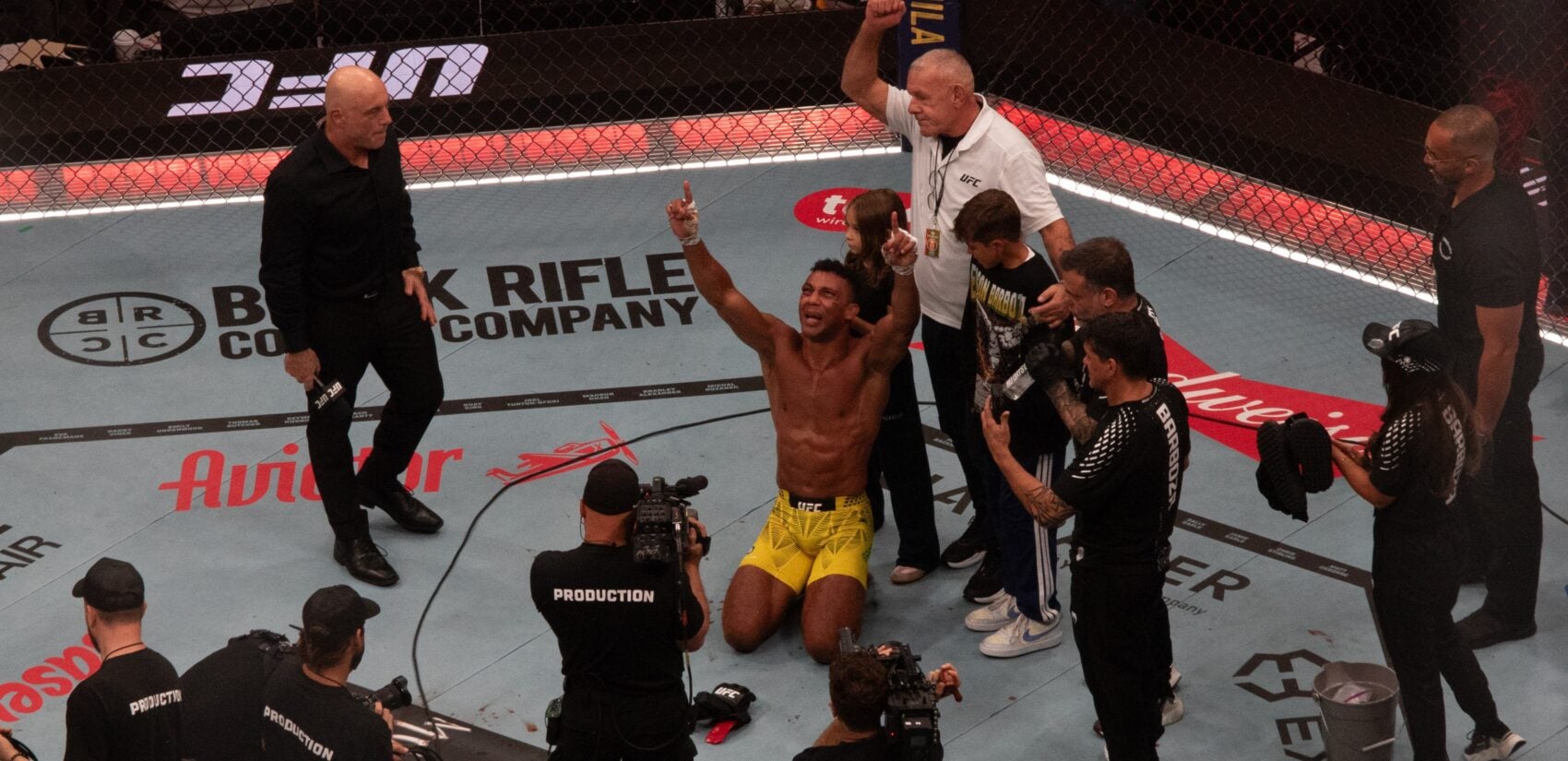 Edson Barboza in the octagon pointing upward with both arms