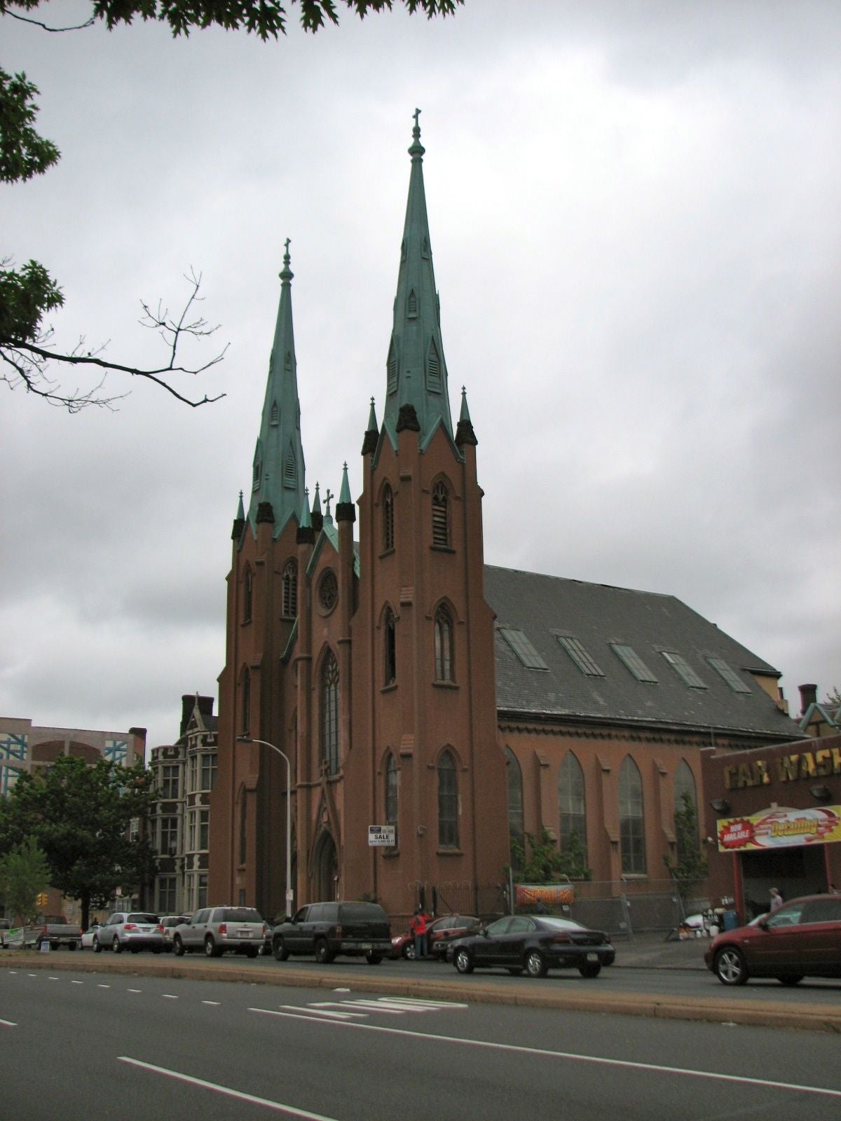 The twin spires of the Church of the Assumption on Spring Garden Street dwarf the former school building next door.