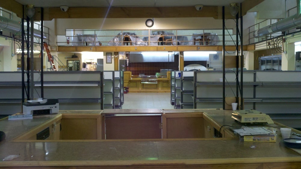 The checkout area with shelves and the kitchen beyond