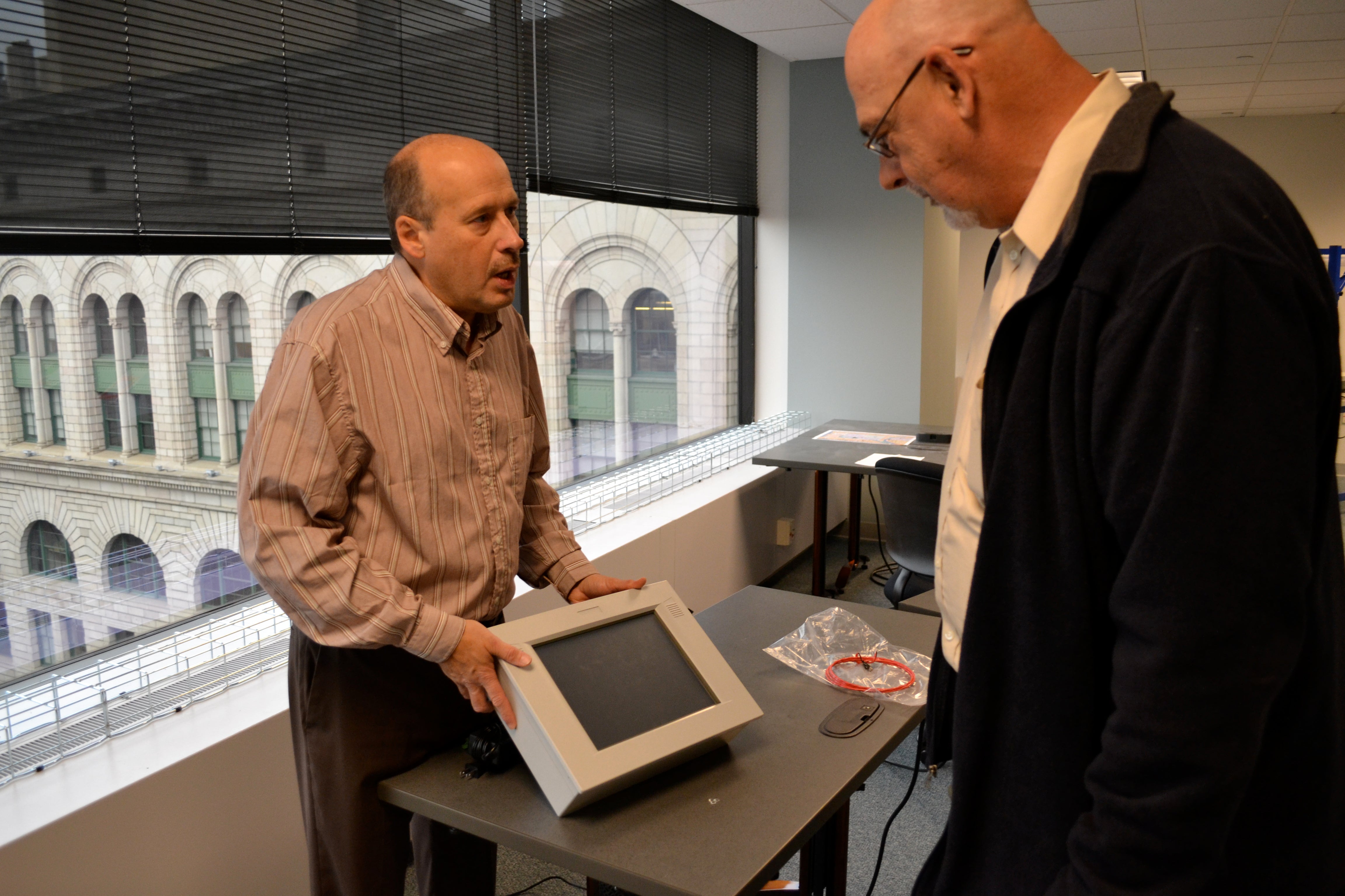 John McGee, chief officer of new payment technology, shows a model of what the vending machine touch screen may look like