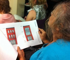 Neighbor Liz Heller looks over plans for The Cliffs townhouses. (Amy Z. Quinn/for NewsWorks)