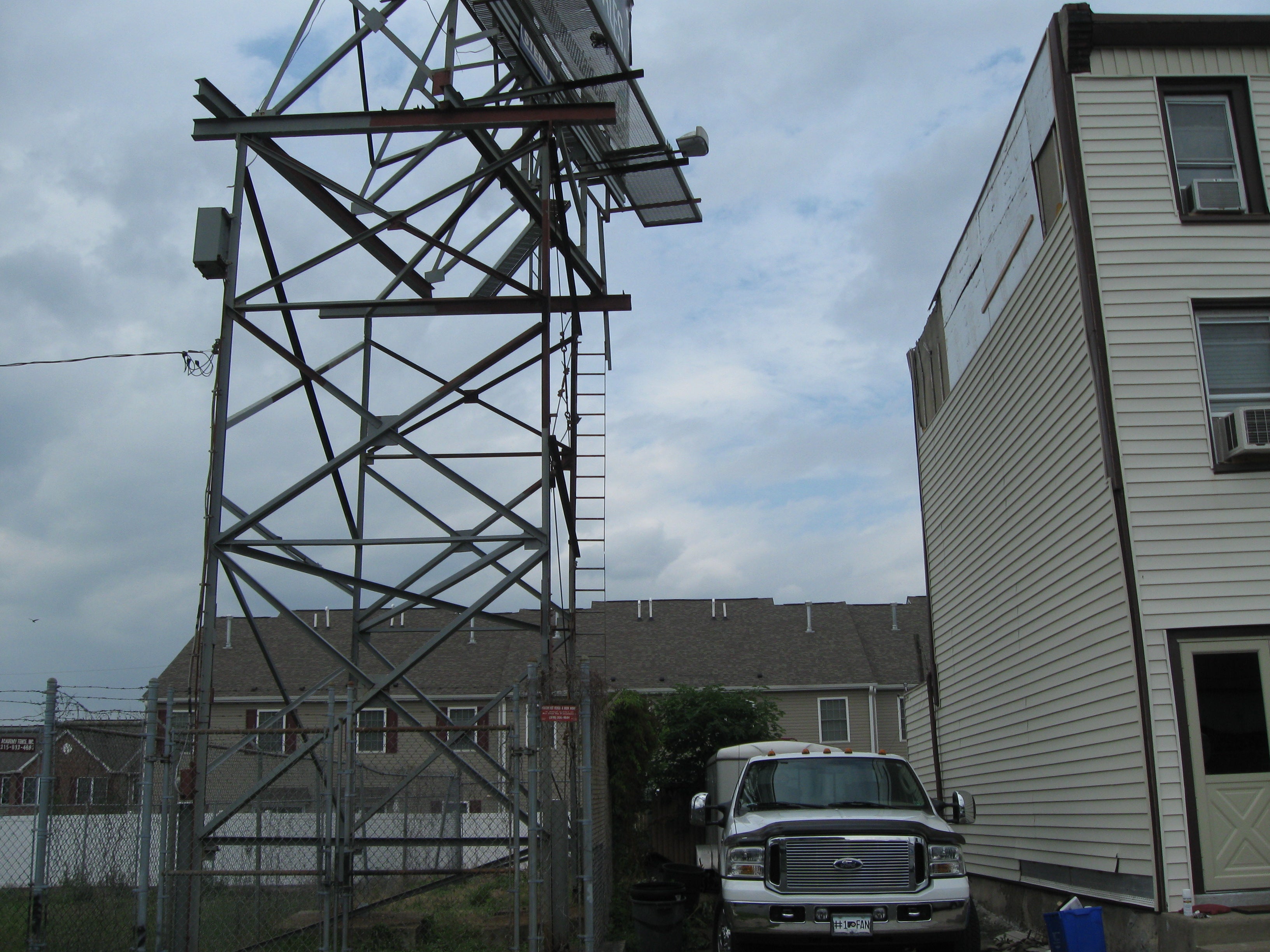 Billboards encroach on a garage, cheek by jowl