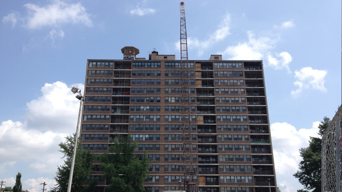 Activity at the Queen Lane Apartments site now sees a crane standing taller than the high-rise building. (Brian Hickey/WHYY)