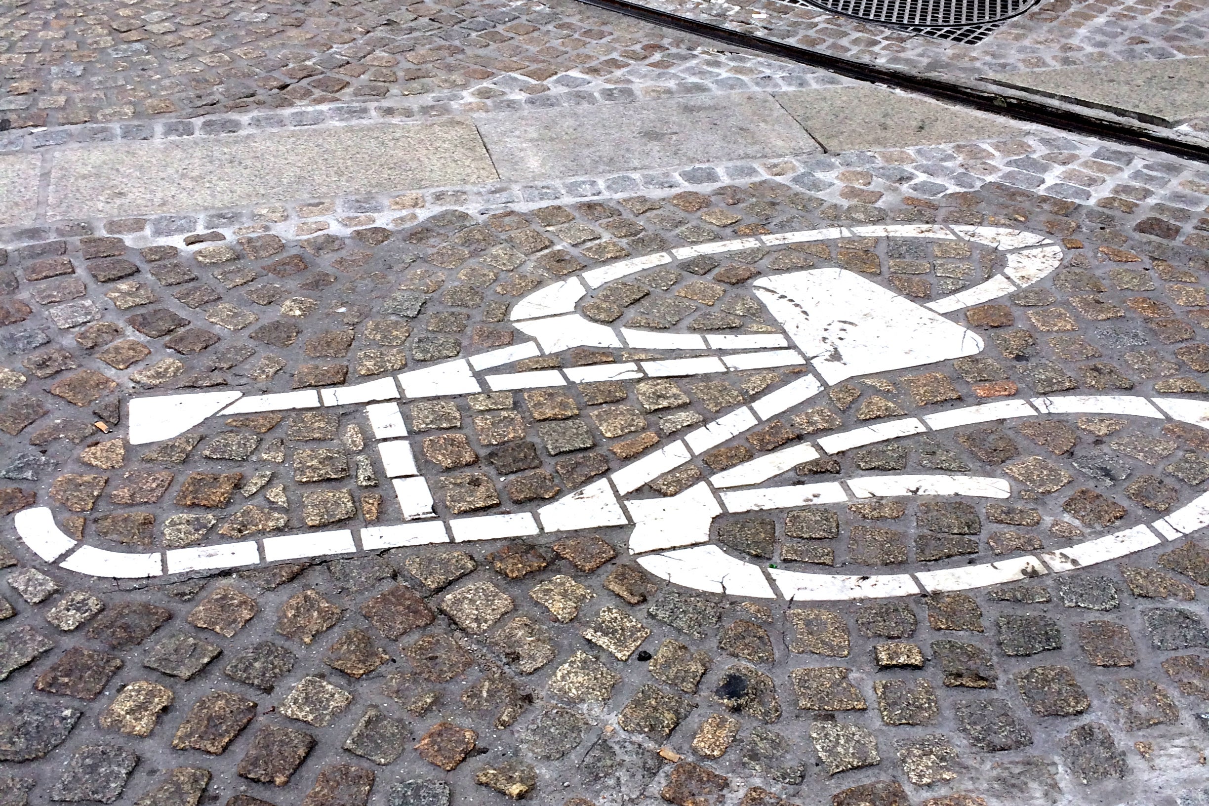Amsterdam bike zone marking on cobblestone street. 