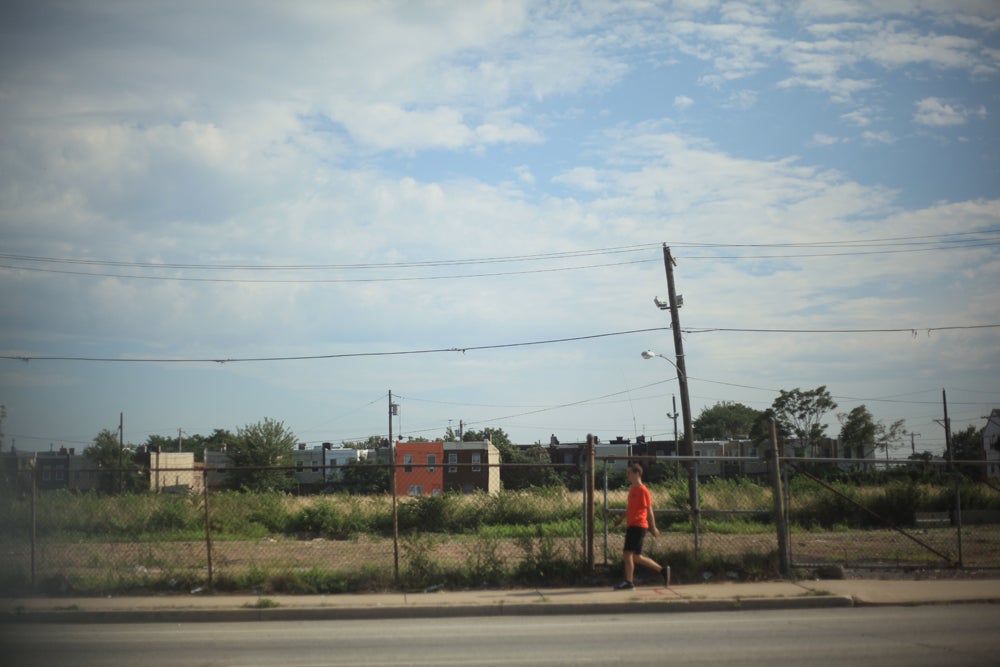 A pedestrian walks by a gated lot located along Washington Ave. in Southwest Center City. | Photo: Neal Santos