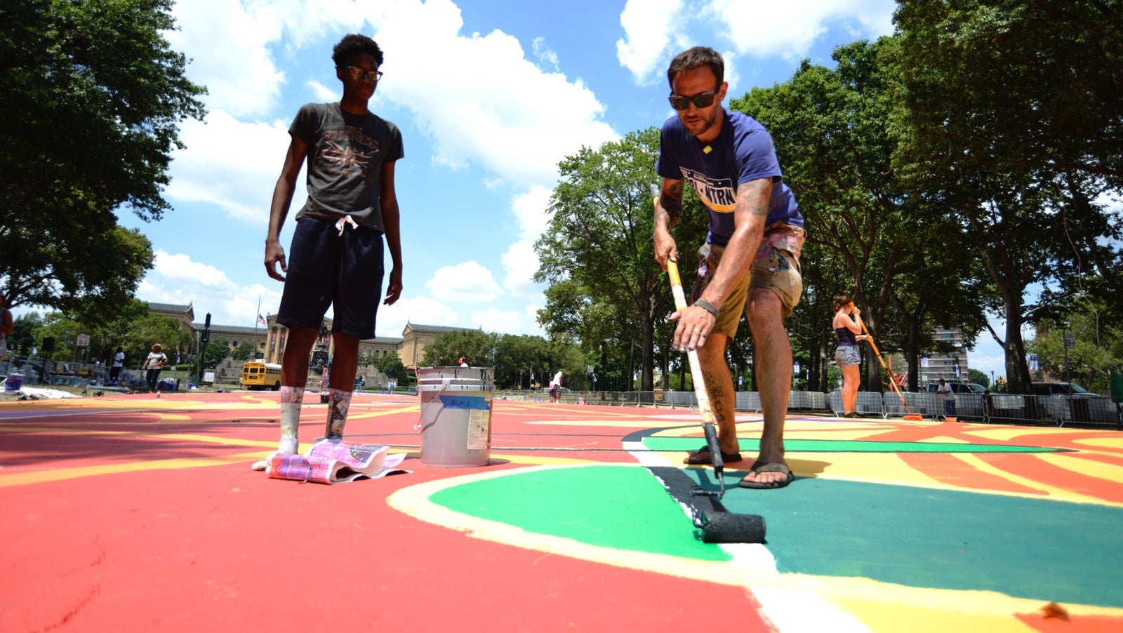 A student listens to the instructions of  lead muralist Brad Carney. (Bastiaan Slabbers for NewsWorks)