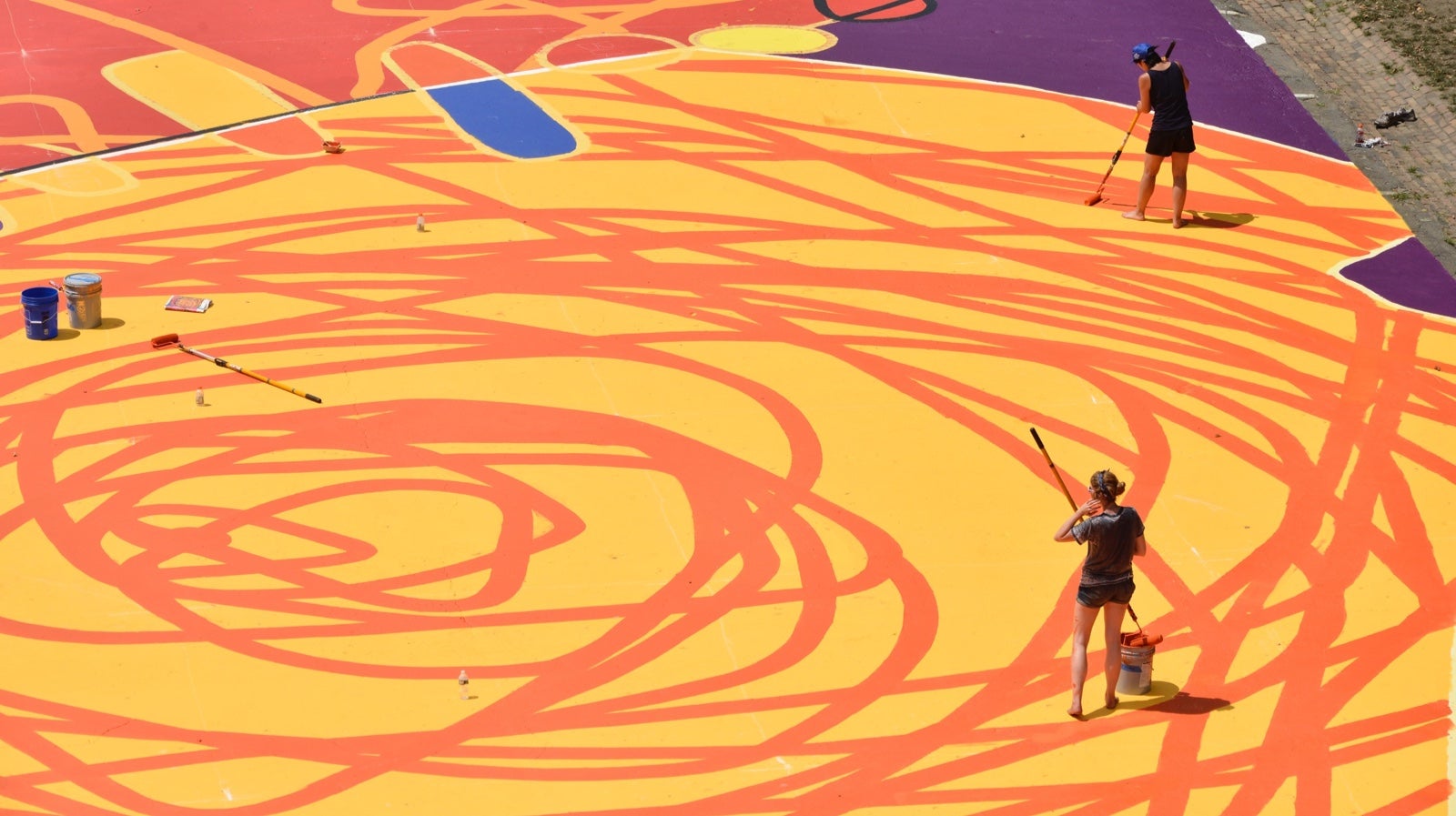 Painters work in the lines in the dance section in front of the stage, on the south side of Eakins Oval. (Bastiaan Slabbers for NewsWorks)