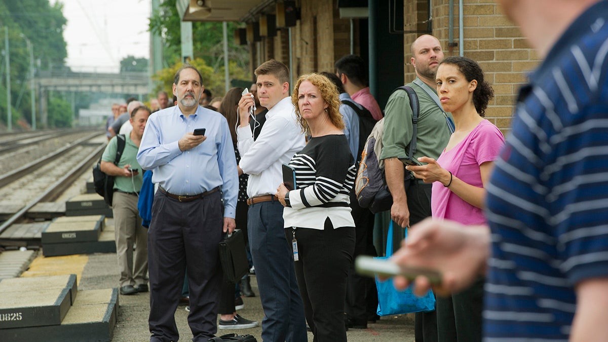 Passengers at the Ardmore Station look up the tracks as a SEPTA train approaches. (Jonathan Wilson for Newsworks)
