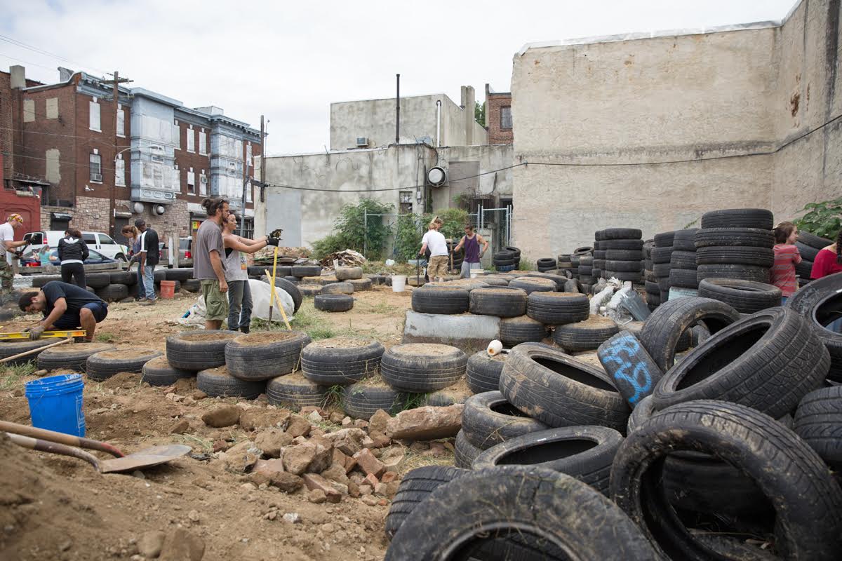Urban earthship: At a vacant lot near Lancaster Avenue and 41st St, volunteers use hundreds of tires to build an urban earthship. | Lindsay Lazarski / WHYY