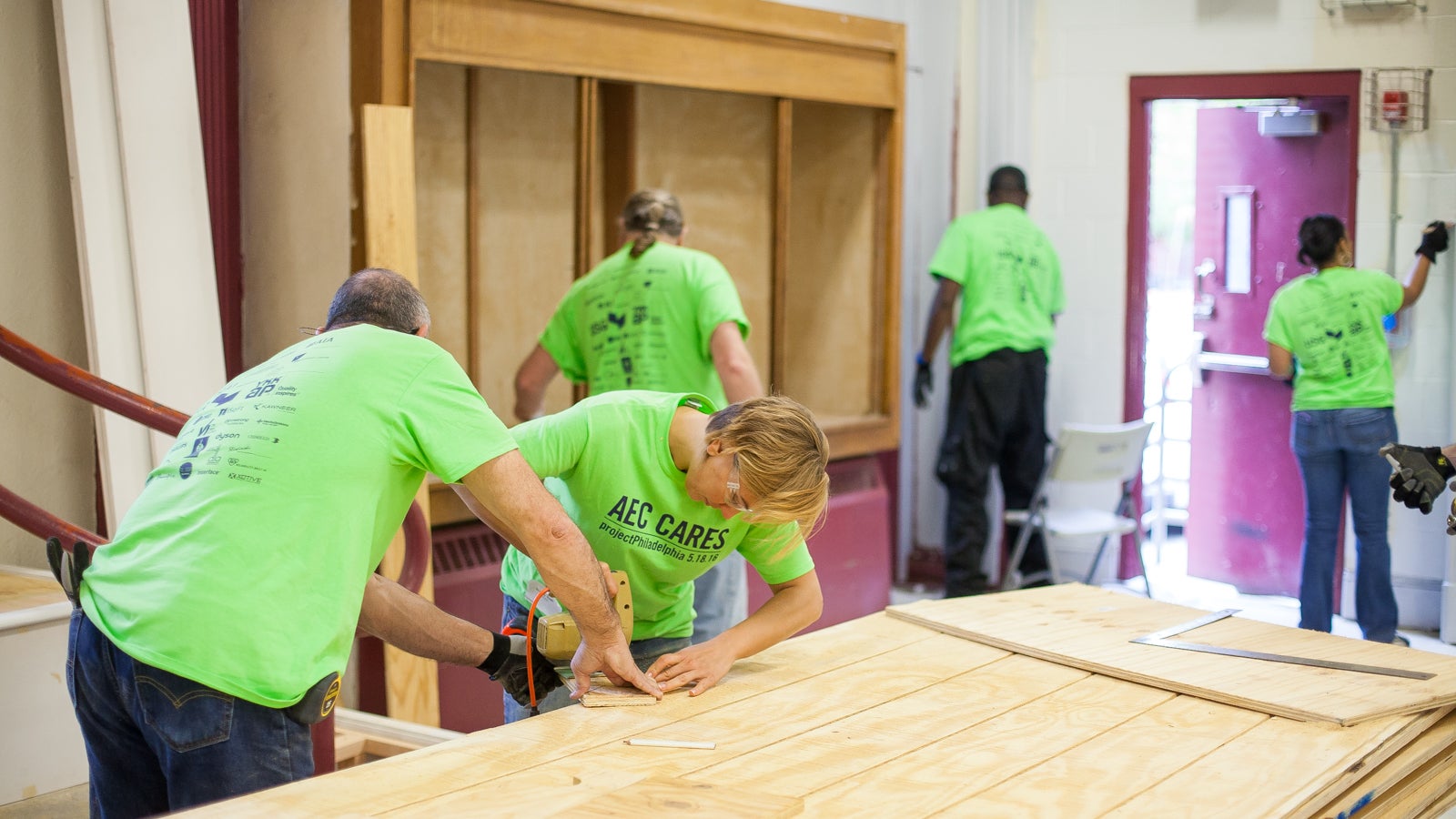 Volunteers cut up wood during a blitz build, to rehab the Athletic Recreation Center in the Sharswood neighborhood in North Philadelphia. (Brad Larrison for NewsWorks)