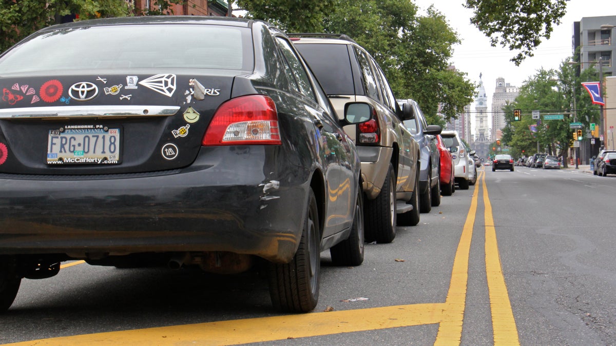 A line of cars parked in the median on South Broad Street (Emma Lee/WHYY)
