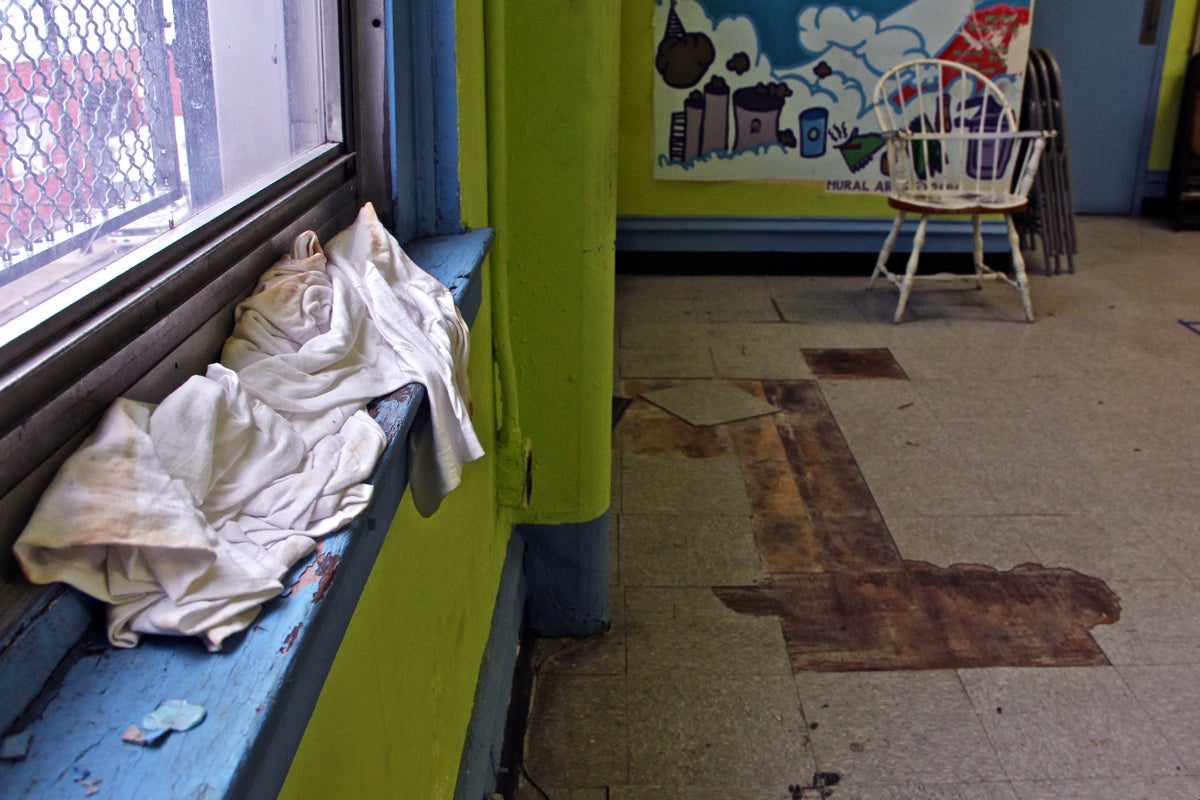 A T-shirt catches the drips from a leaking window frame in a multi-purpose room used by children at Vare Rec Center. | Emma Lee/WHYY