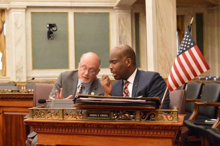 Councilmen Bill Greenlee (left) and Derek Green talk business during a hearing Monday. (Tom MacDonald, WHYY)