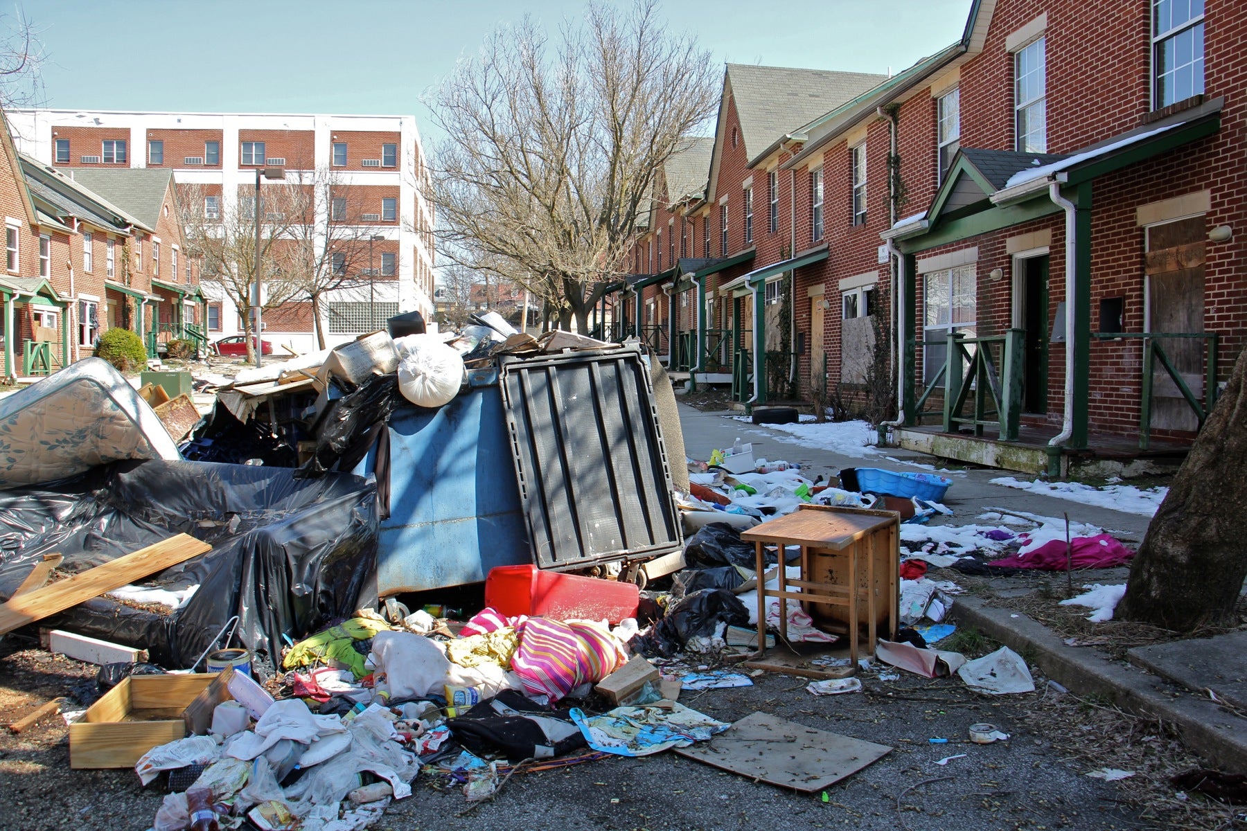 Garbage is piled in front of an apartment complex in Lower Germantown. (Emma Lee/WHYY)