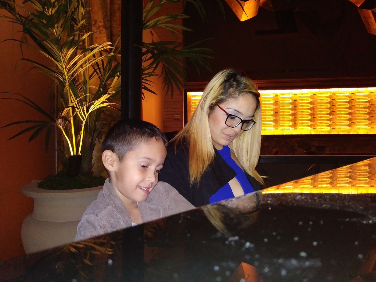 Muriel Rivera and her son Yeriel playing the piano at the hotel where she's been staying since November. 