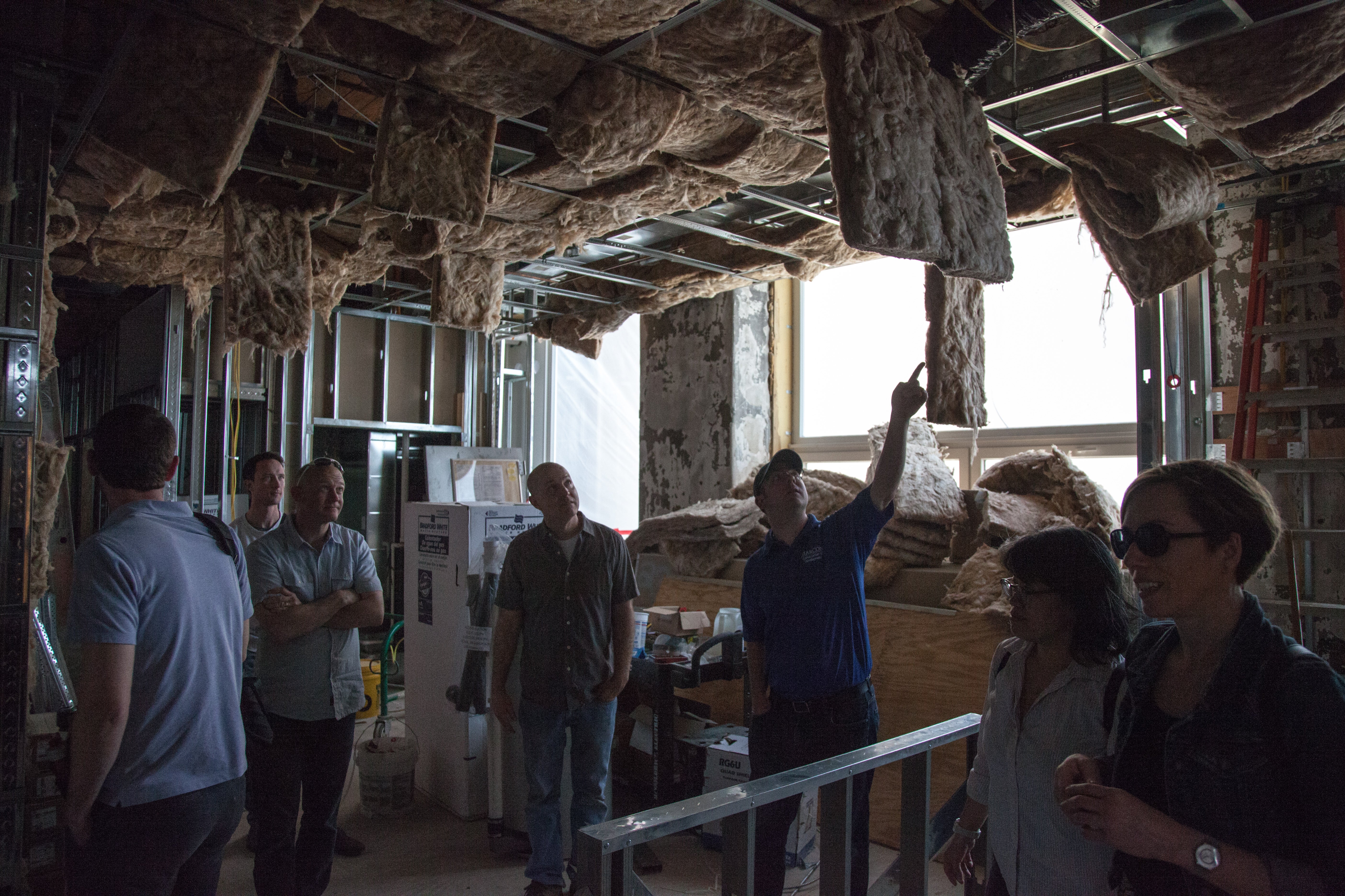 Tour attendees check out the fiberglass insulation inside Orinoka Civic House. Credit: Lowell Brown/NKCDC