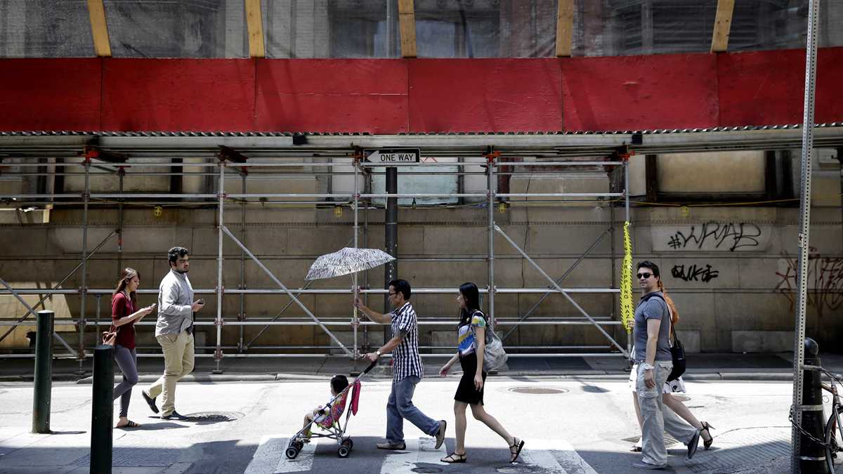 People cross a street near a construction site on Market Street in Center City, Philadelphia. (AP Photo/Matt Rourke)