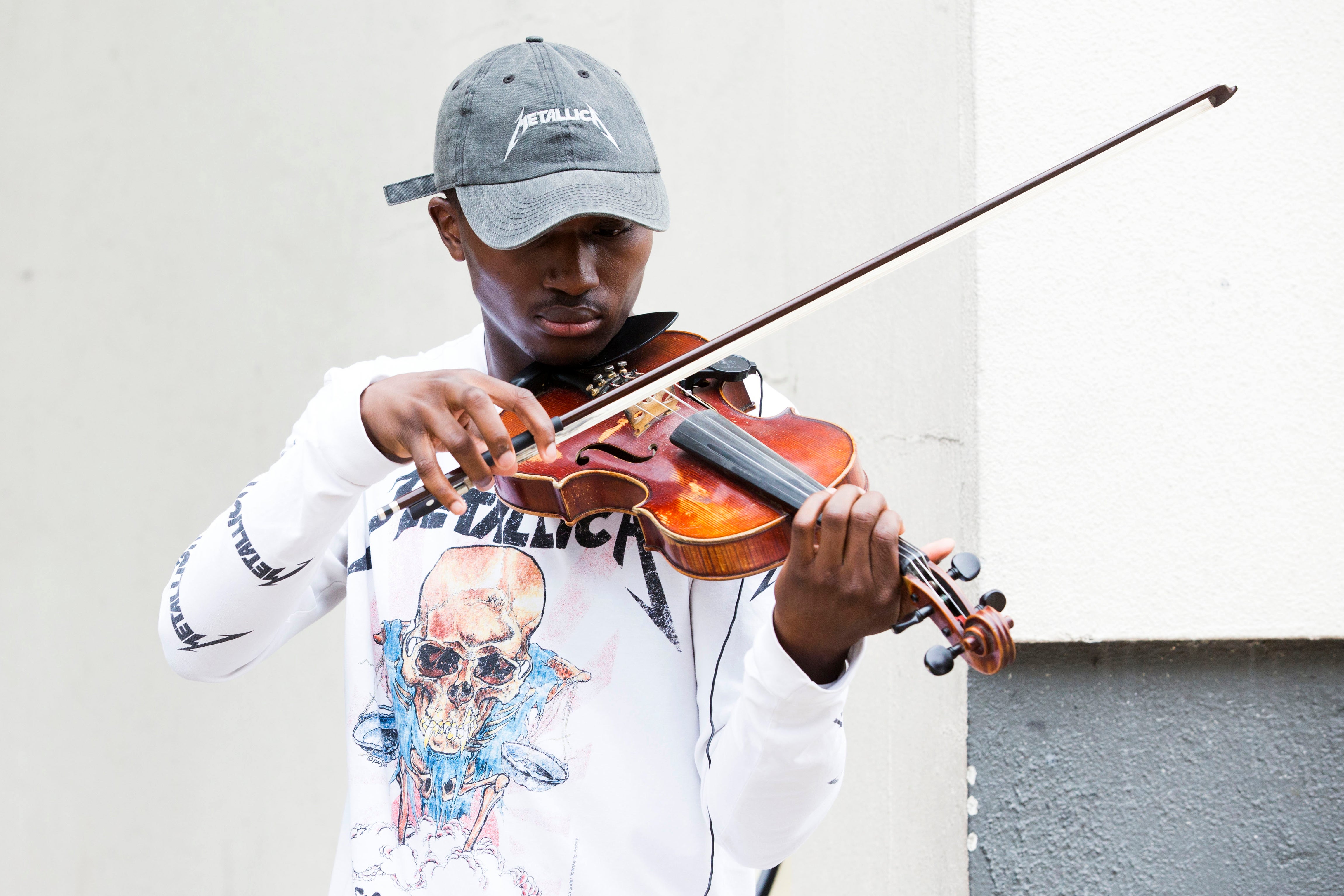 Rickey Turner, 21, plays the violin outside the Made in America festival.