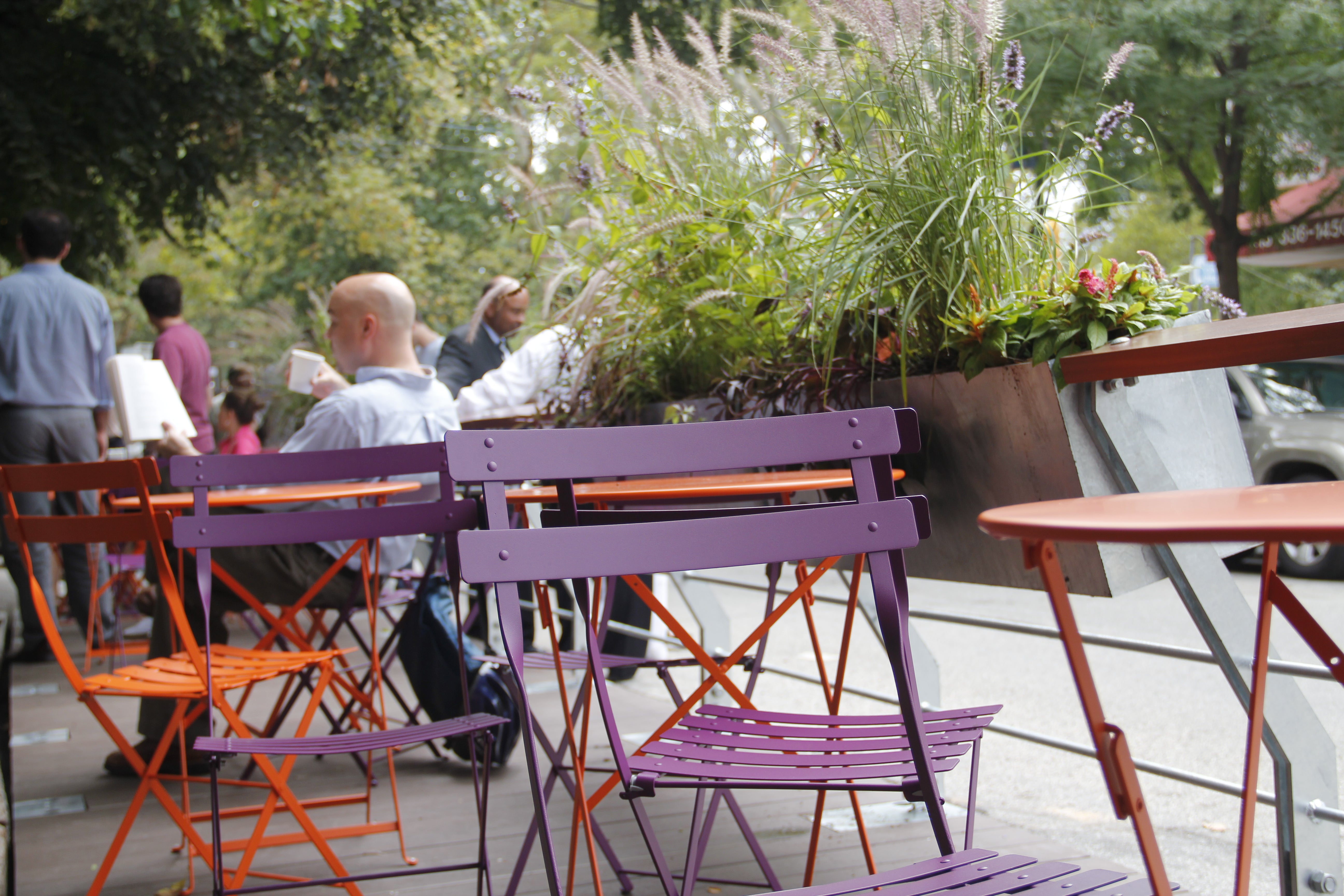 The planters are being watered by a neighbor. The tables and chairs are being cleasned by the neighboring Green Line Cafe.