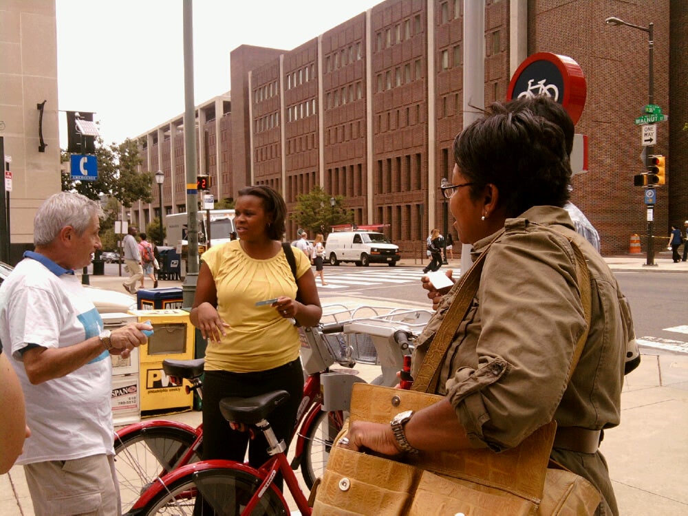 Lakeisha Bishop, Bonny West and Serita Lewis (behind West) talk to Russell Mendin about bike share